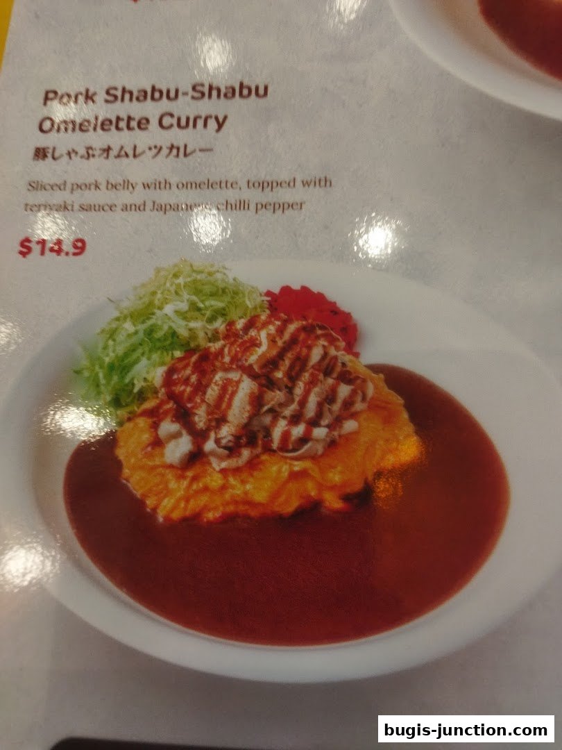 A menu item featuring Pork Shabu-Shabu Omelette Curry with sliced pork belly and teriyaki sauce.
