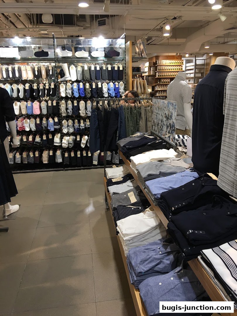 Interior view of a MUJI store showcasing a wide selection of socks and folded shirts.