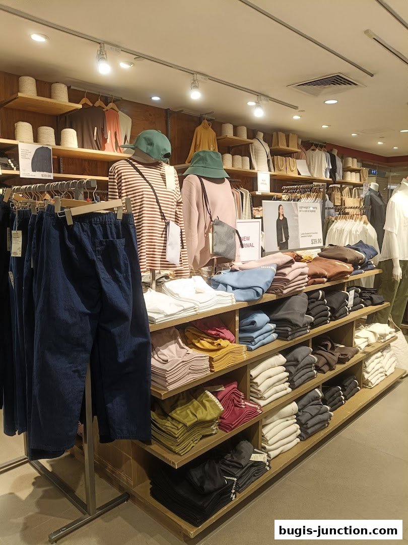 Interior view of a MUJI store showcasing folded apparel and mannequins with new arrivals.