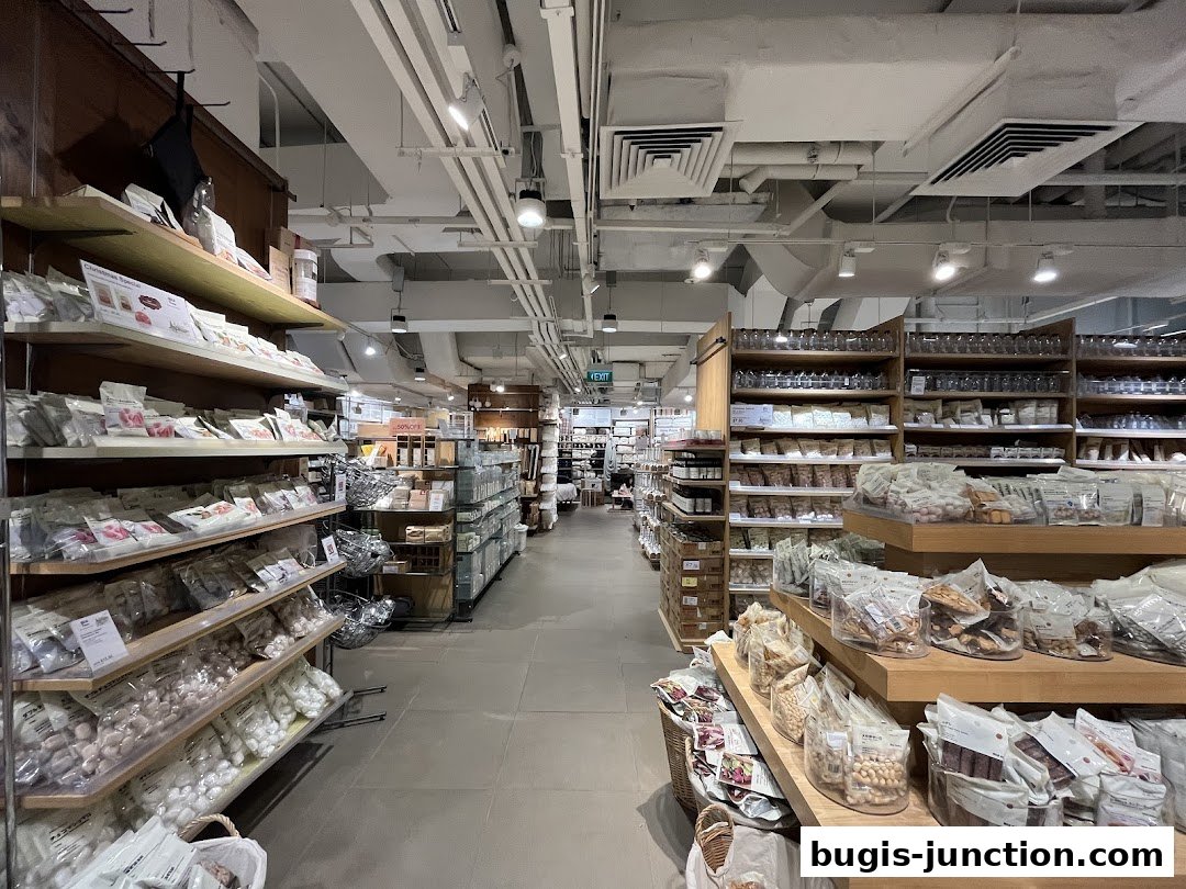 Interior view of a MUJI store showcasing shelves stocked with various food products and household items.
