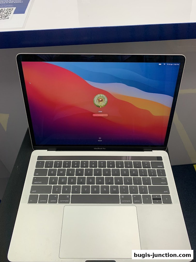 A MacBook Pro laptop is displayed with its login screen and keyboard.