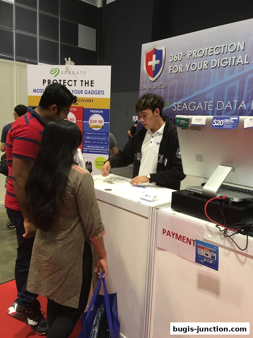 Customers interact with a sales representative at a Seagate data recovery booth.