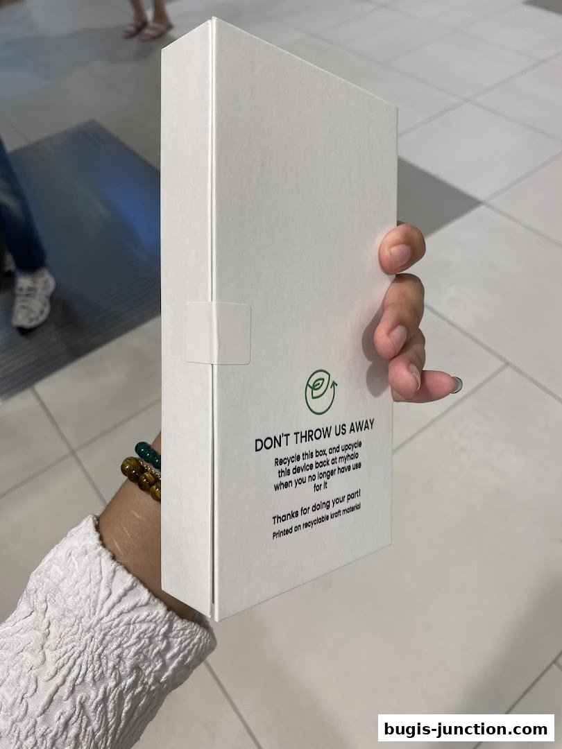 A hand holds a white box with recycling instructions from myhalo CircularXchange.