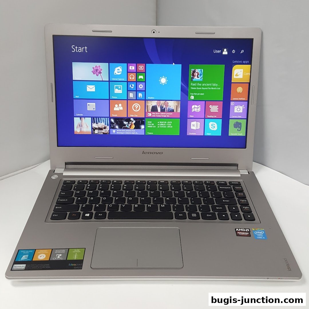 A silver Lenovo Ideapad laptop with the Windows 8 start screen displayed.