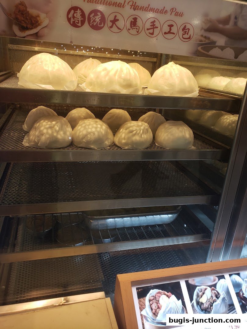 A display case filled with freshly steamed buns, showcasing traditional handmade pau.