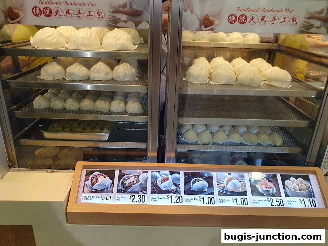 A display of various steamed buns and dim sum items with prices.