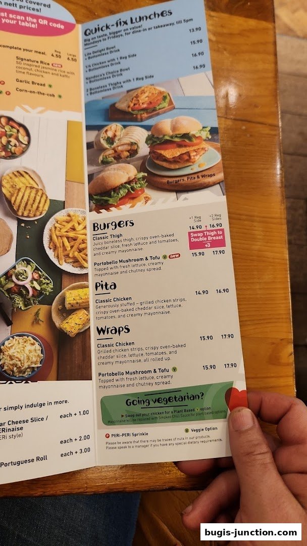A close-up of a Nandos menu featuring burgers, pitas, and wraps with prices.