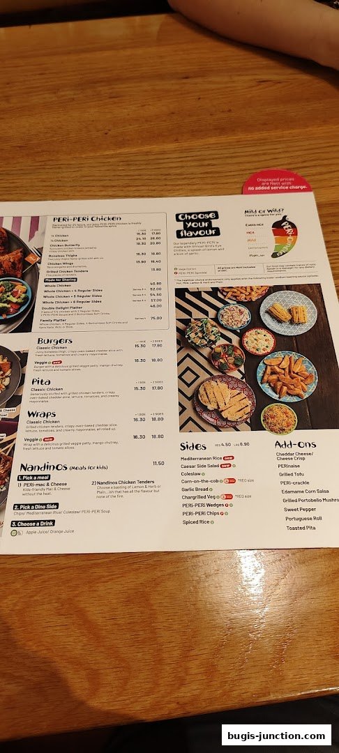 A menu from Nandos featuring PERi-PERi chicken, burgers, pita, wraps, sides, and add-ons.
