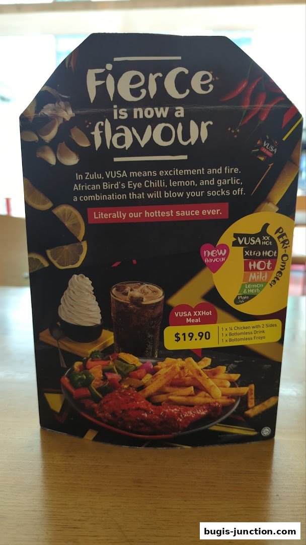 A promotional display for Nandos' new VUSA XXHot meal with chicken, sides, drink, and froyo.