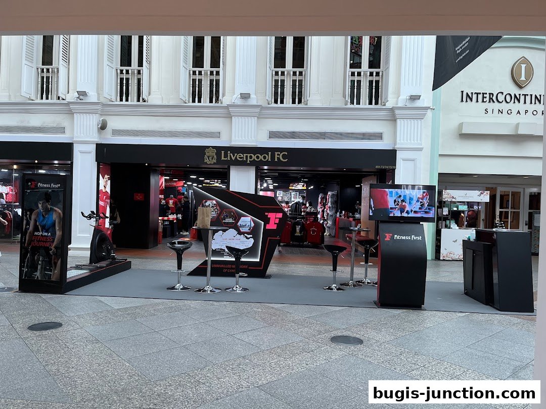 A Liverpool FC store and a Fitness First promotional display are visible.