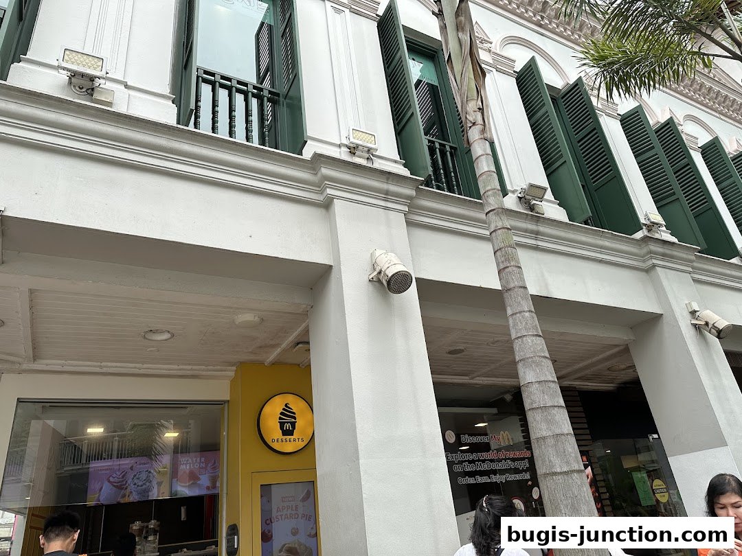 Exterior view of a McDonald's Desserts shop with green shutters and a palm tree.