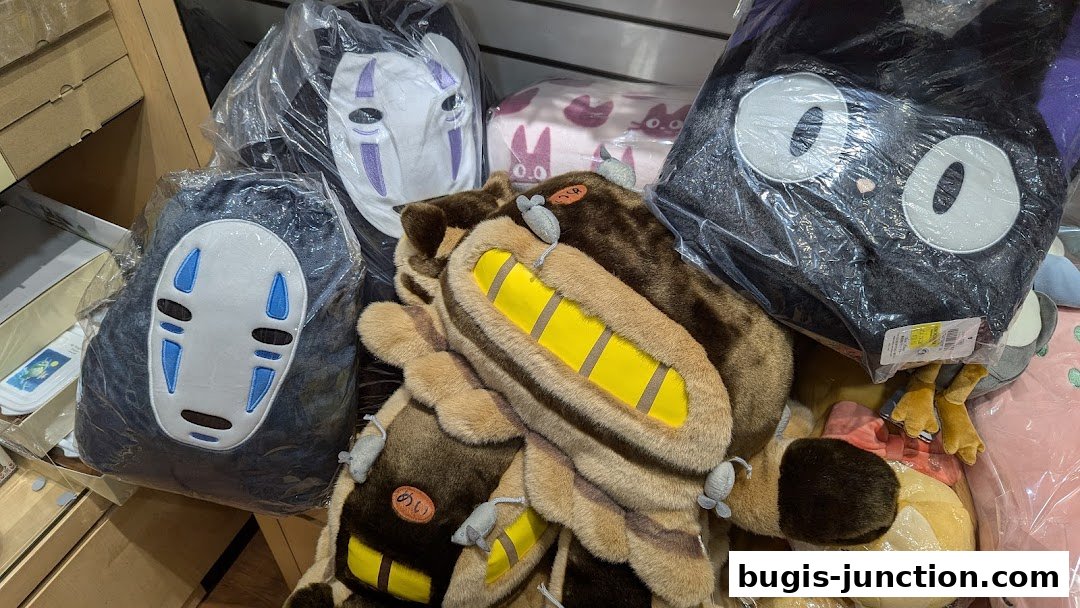 A collection of plush toys featuring characters from Studio Ghibli films, including Totoro and No-Face.