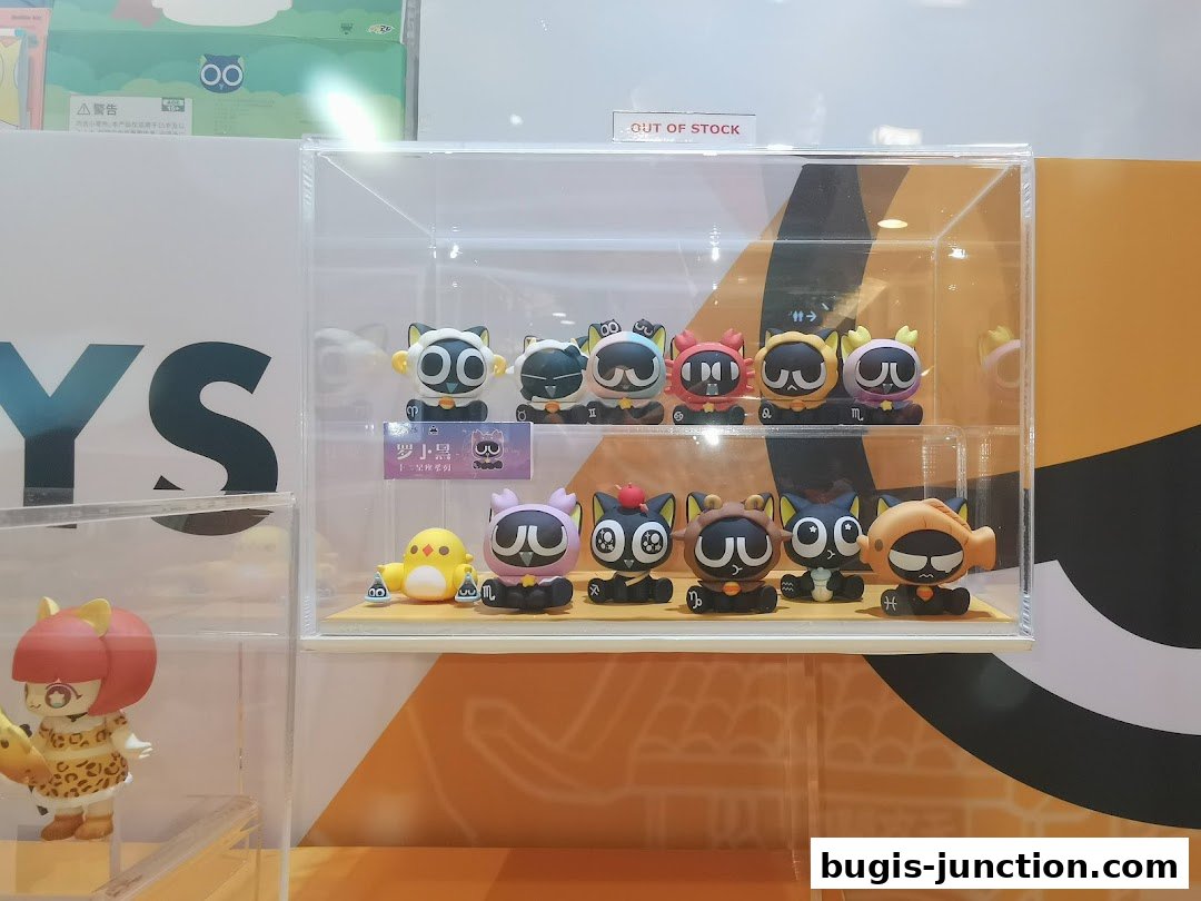 Display case filled with cute zodiac-themed cat figurines and a yellow chick toy.