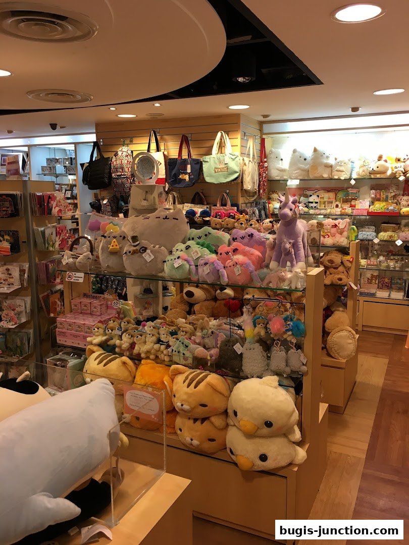 A wide variety of plush toys and tote bags are displayed in a retail store.