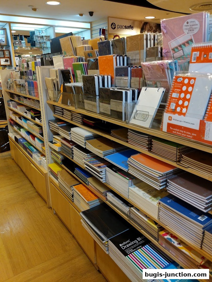 A wide selection of notebooks and stationery items displayed on shelves in a retail store.