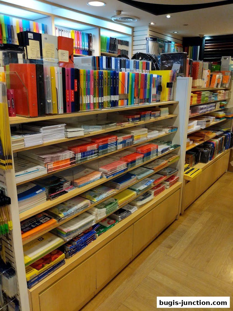 Shelves stocked with colorful stationery, binders, and office supplies in a retail store.