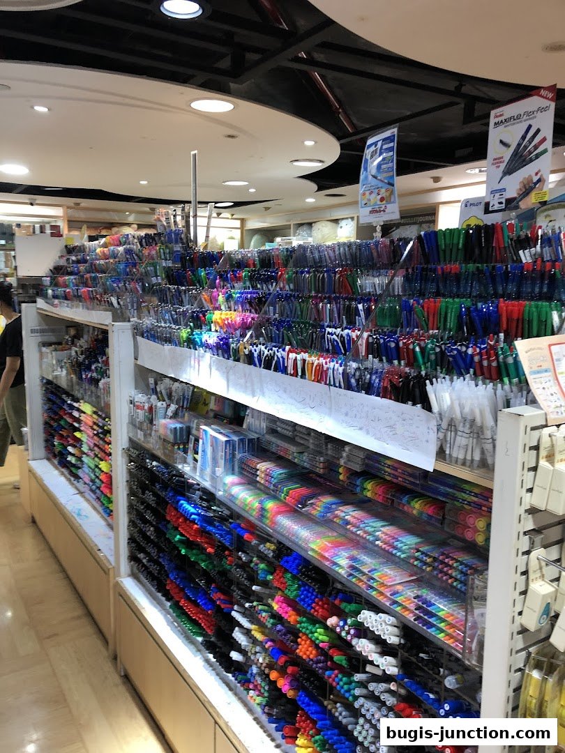 A wide selection of colorful pens and stationery items displayed on shelves in a retail store.