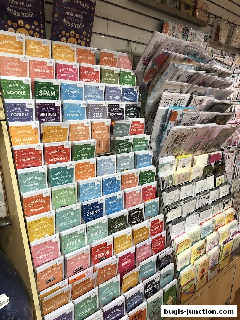A display of greeting cards with various witty and humorous messages in English and Singlish.