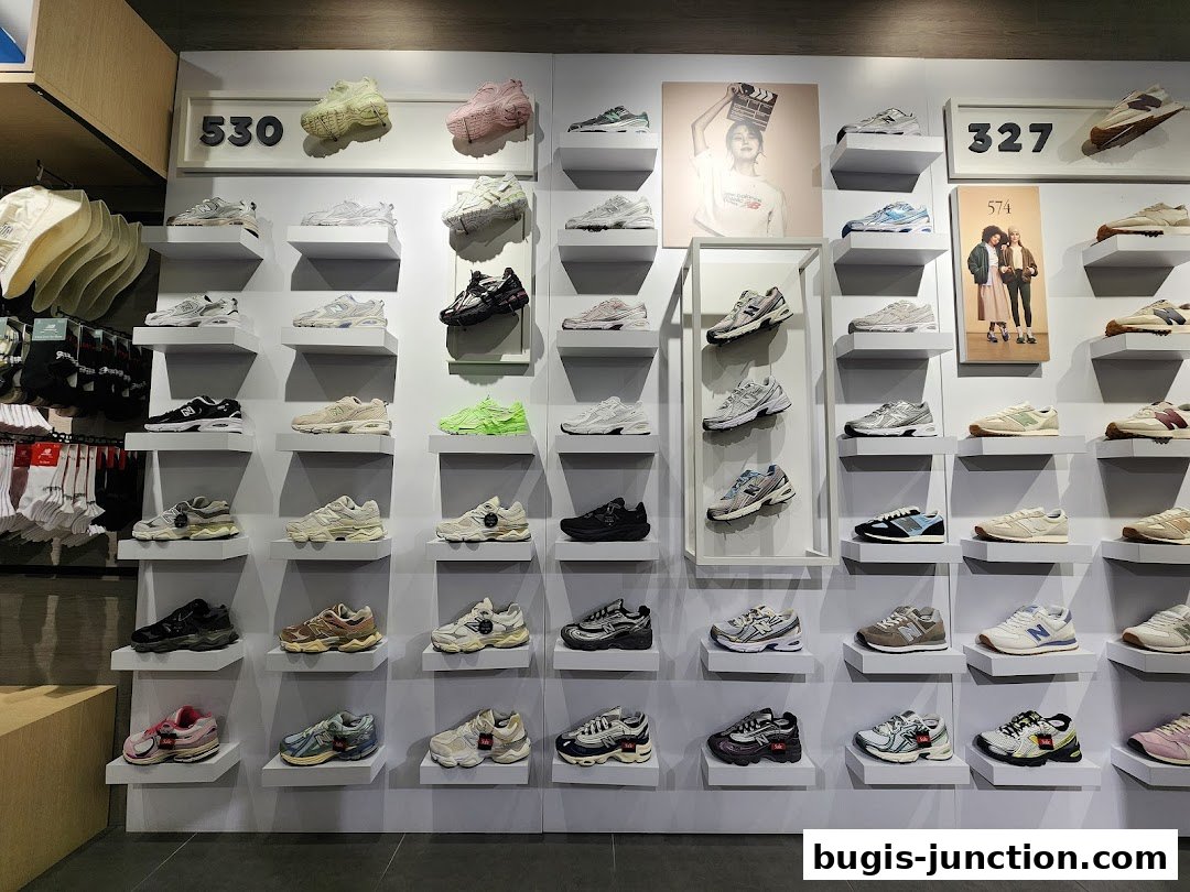 A wall display of New Balance shoes and apparel in a retail store.