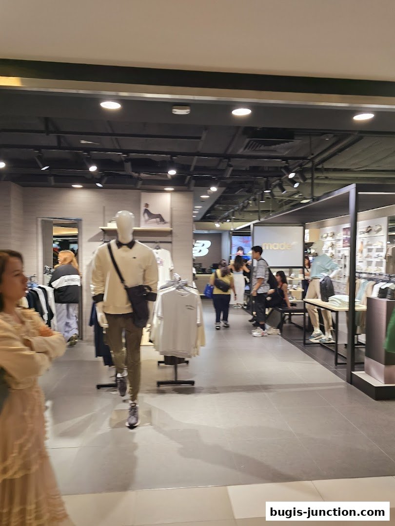 Interior view of a New Balance store with mannequins and clothing displays.