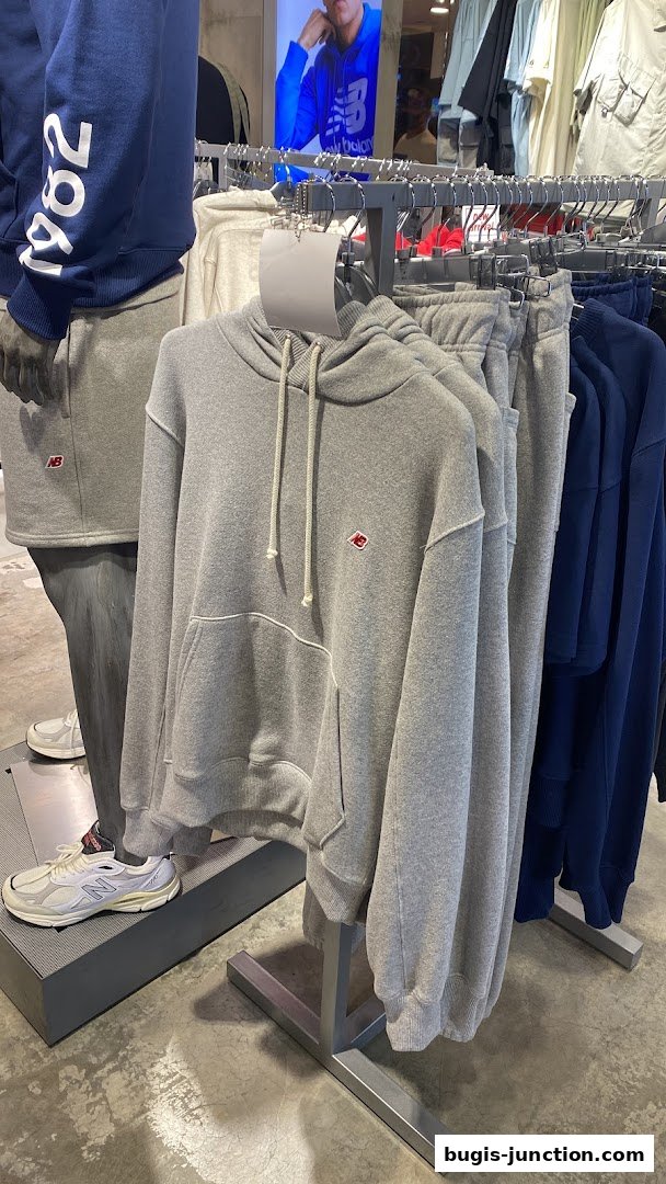 New Balance store interior showcasing grey hoodies and sweatpants on display.