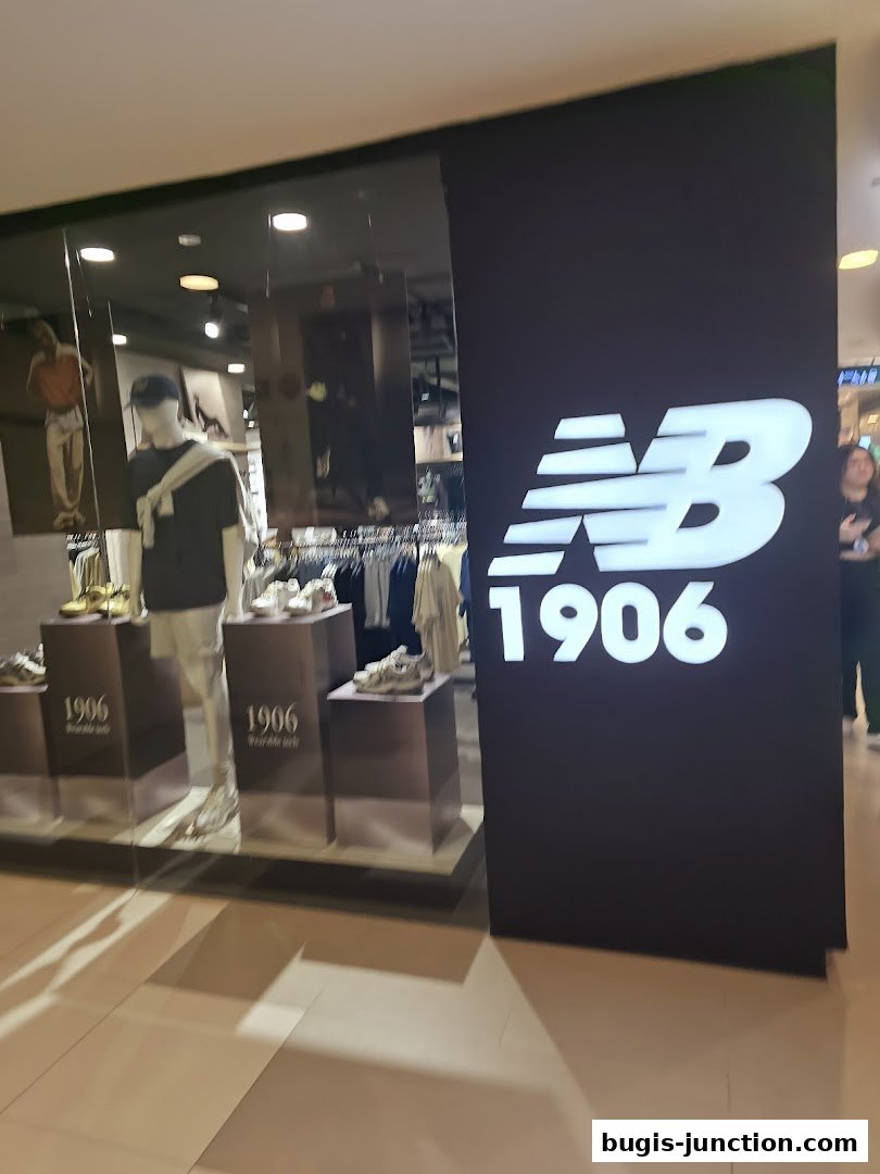 New Balance store front with mannequins displaying apparel and shoes, and prominent branding.