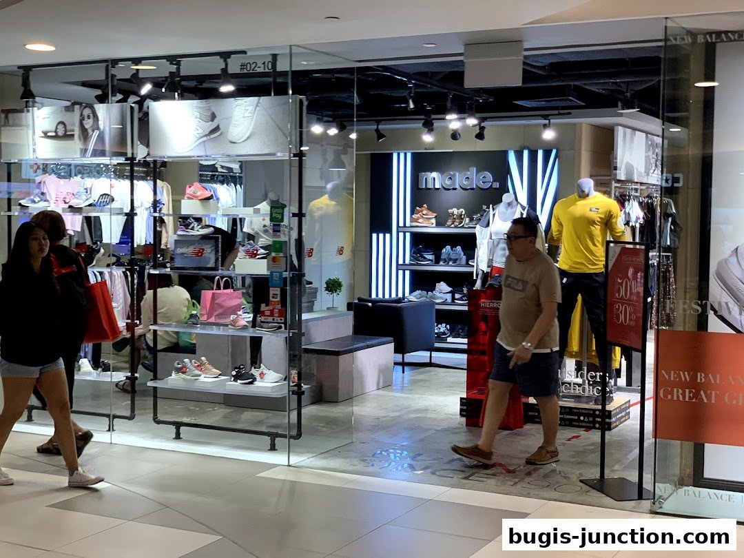 The New Balance store entrance showcases athletic footwear and apparel with mannequins and displays.
