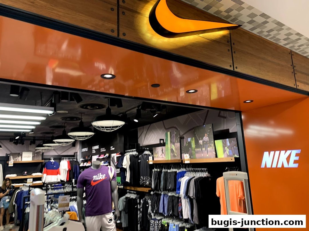 The entrance of a Nike store featuring the iconic Nike logo and displays of athletic apparel.