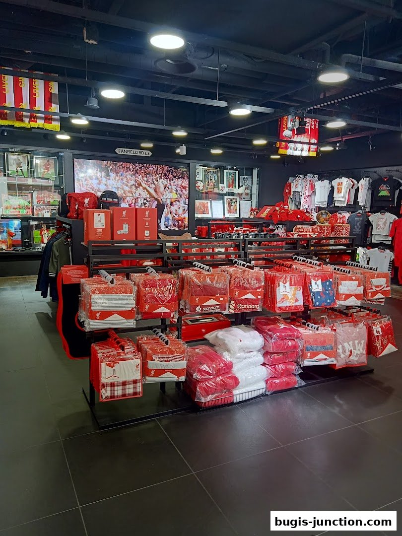 Interior of a Liverpool FC retail store showcasing merchandise like jerseys, bedding, and accessories.