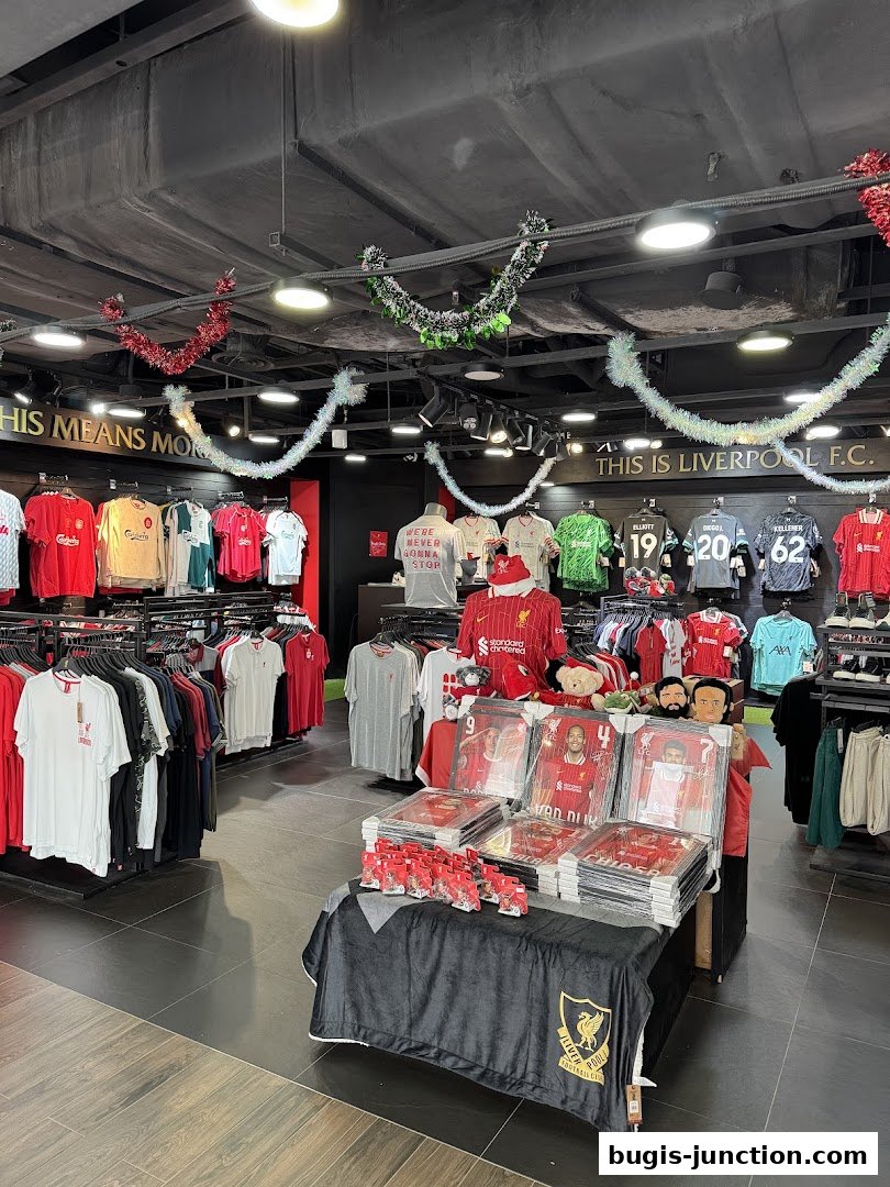 Interior of a Liverpool FC retail store showcasing jerseys, framed photos, and merchandise.