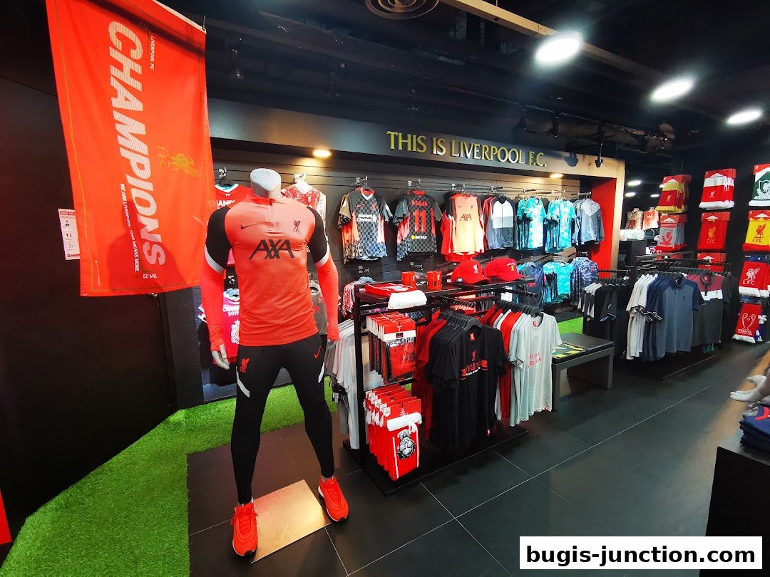 Interior of a Liverpool FC retail store showcasing jerseys, apparel, and merchandise.