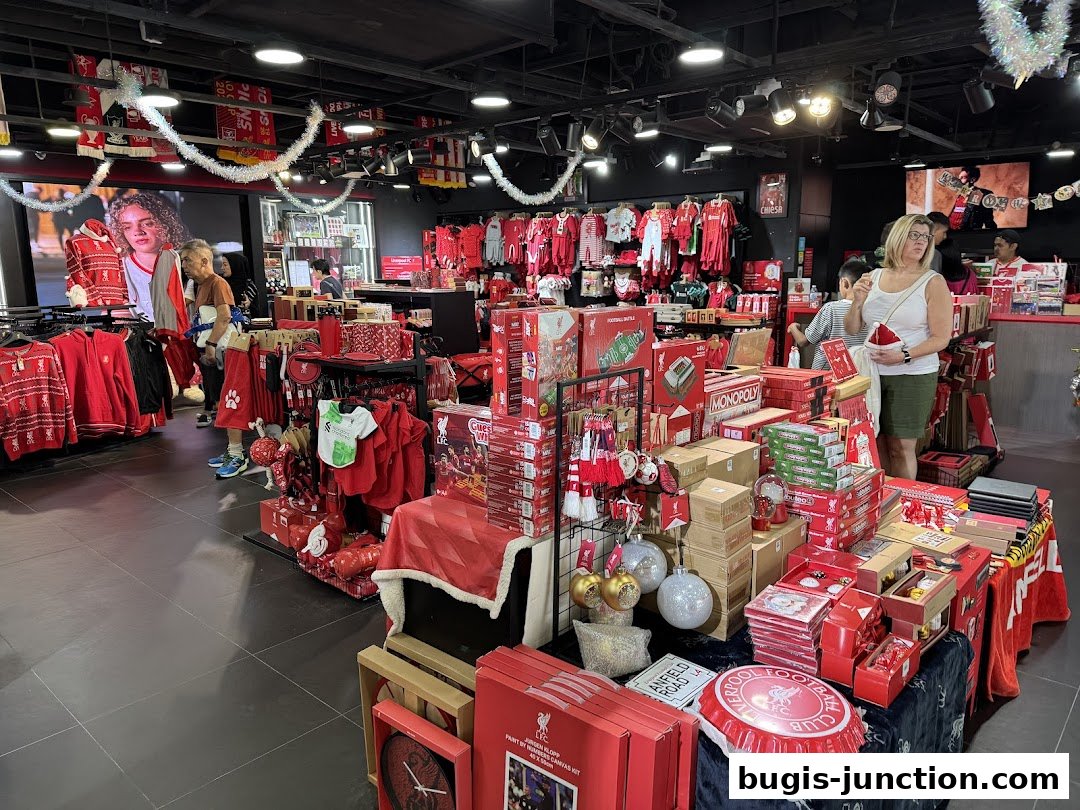 Interior of a Liverpool FC retail store filled with merchandise, including clothing and gift items.