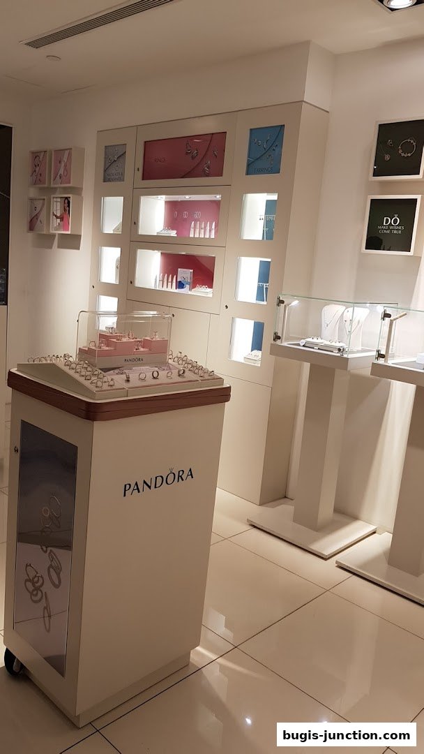 Interior view of a Pandora jewelry store showcasing rings and necklaces on display stands.