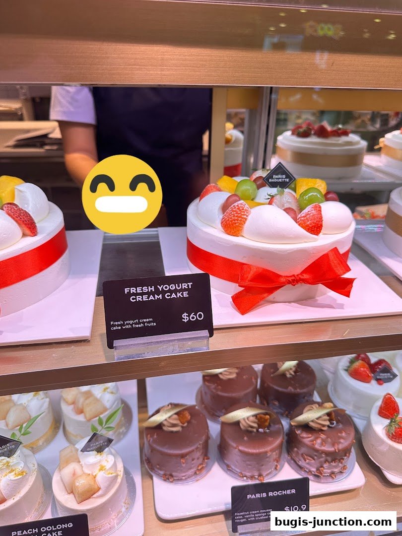A display of beautifully decorated cakes at Paris Baguette, featuring fresh fruits and cream.