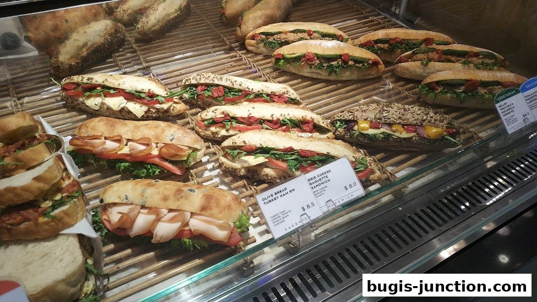 A display case filled with various fresh sandwiches and baguettes.