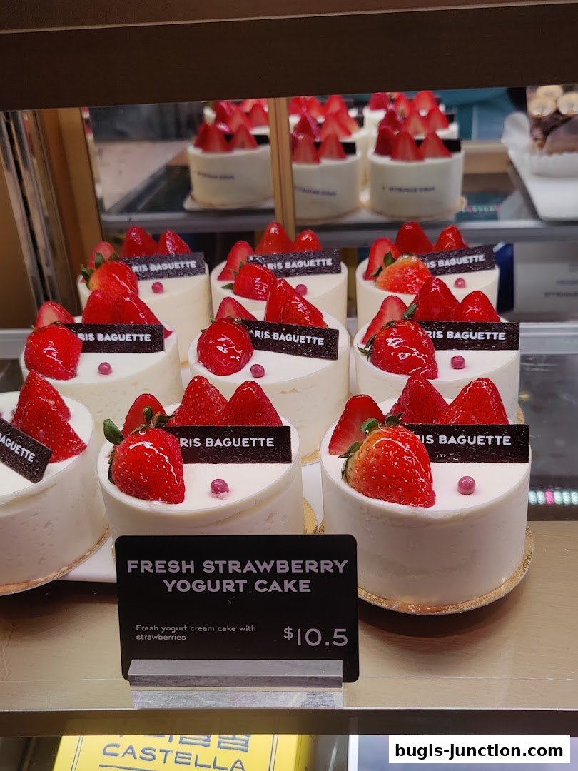 A display of fresh strawberry yogurt cakes with Paris Baguette branding.
