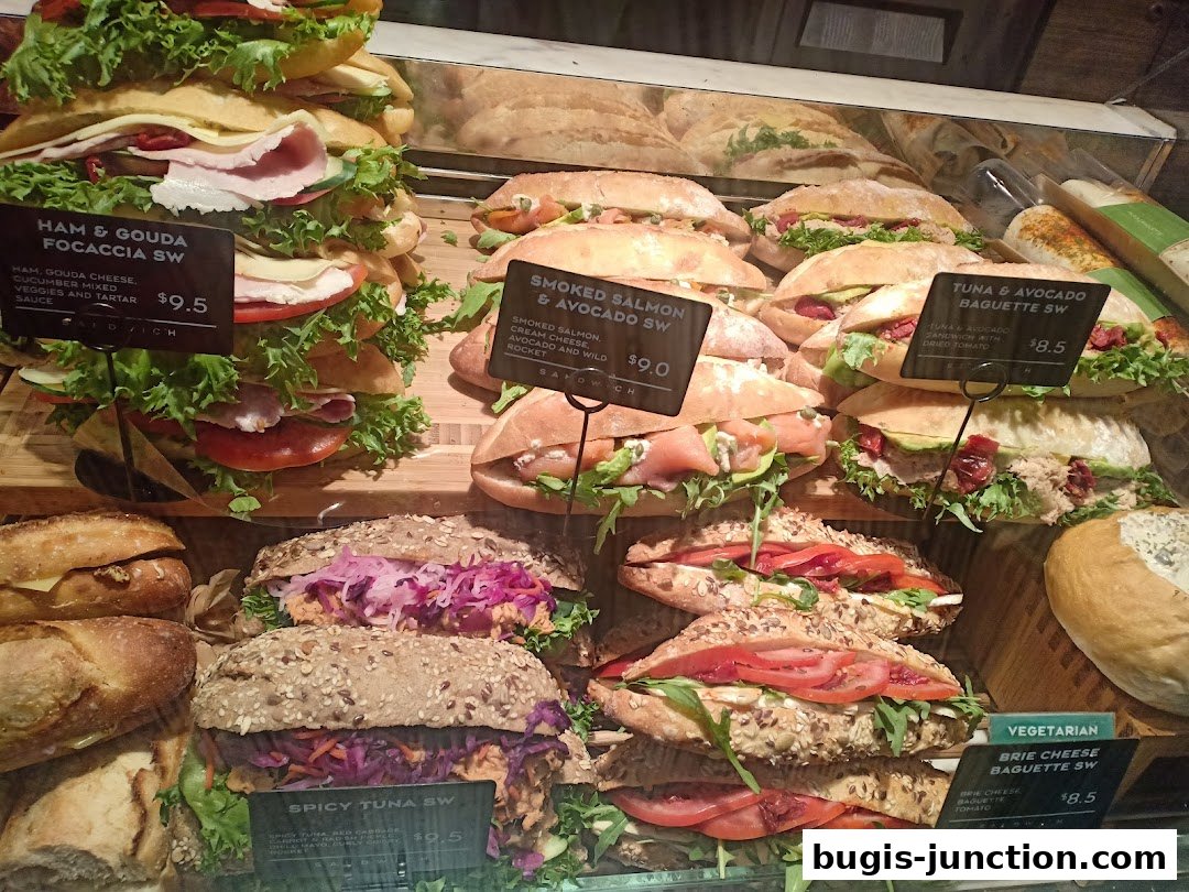 A display of various fresh sandwiches and baguettes with visible price tags.