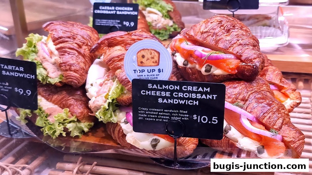A display of gourmet croissant sandwiches with various fillings and prices.