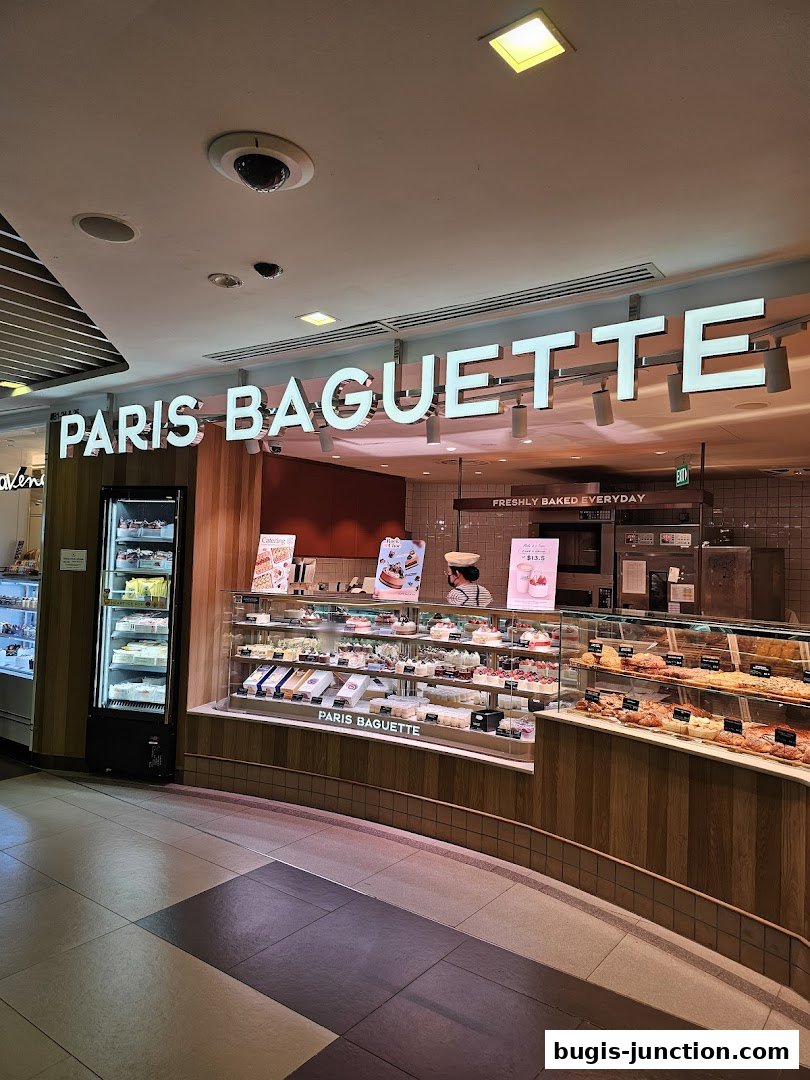 The exterior of a Paris Baguette bakery showcasing a display of cakes and pastries.
