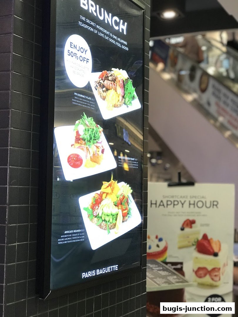 A digital menu board displays brunch items and a happy hour special for shortcakes.