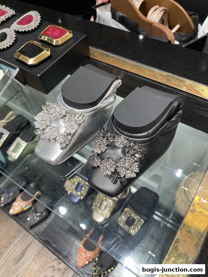 Close-up of elegant embellished flats and decorative shoe accessories on display.