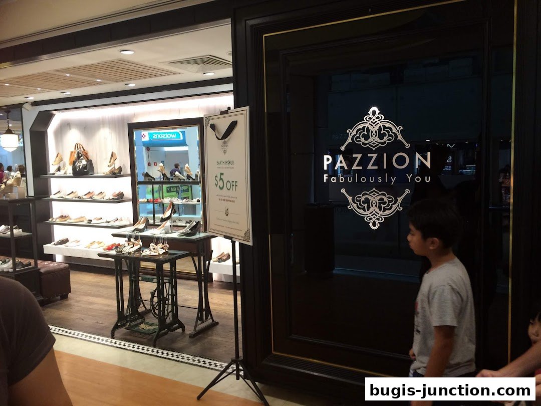 PAZZION shoe store entrance with shoes displayed on shelves and a promotional sign.