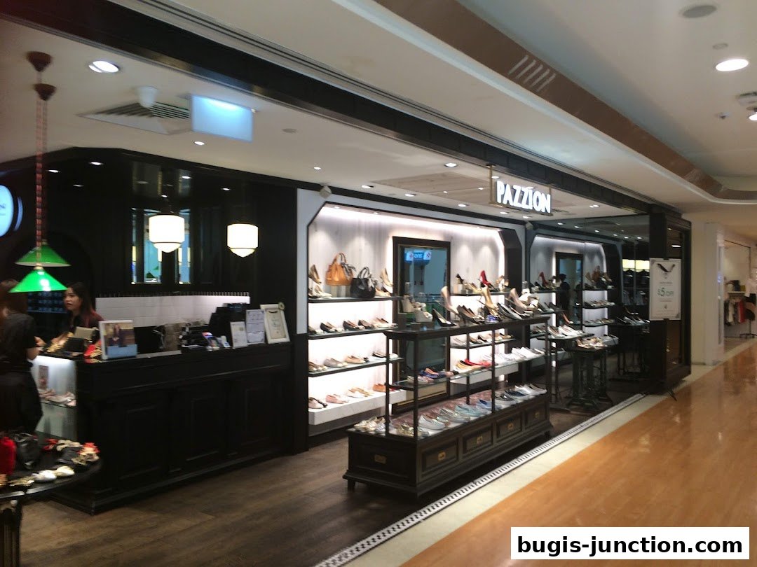 A well-lit shoe store interior with displays of women's shoes and handbags.