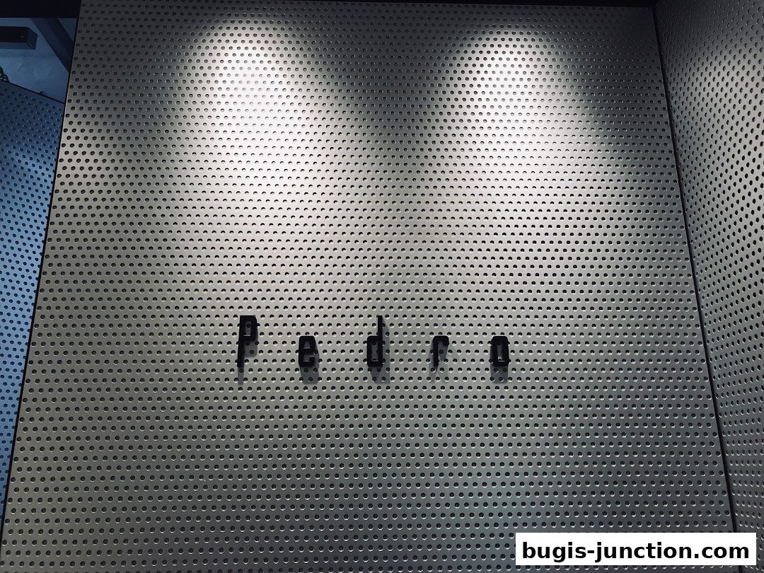 The PEDRO logo is displayed on a perforated metal wall with dramatic lighting.