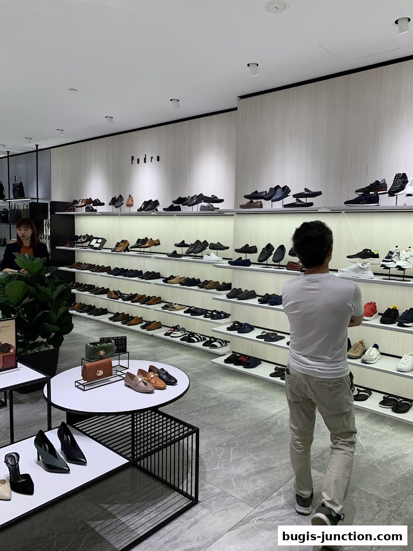 Interior view of a PEDRO shoe store showcasing a wide selection of footwear for men and women.