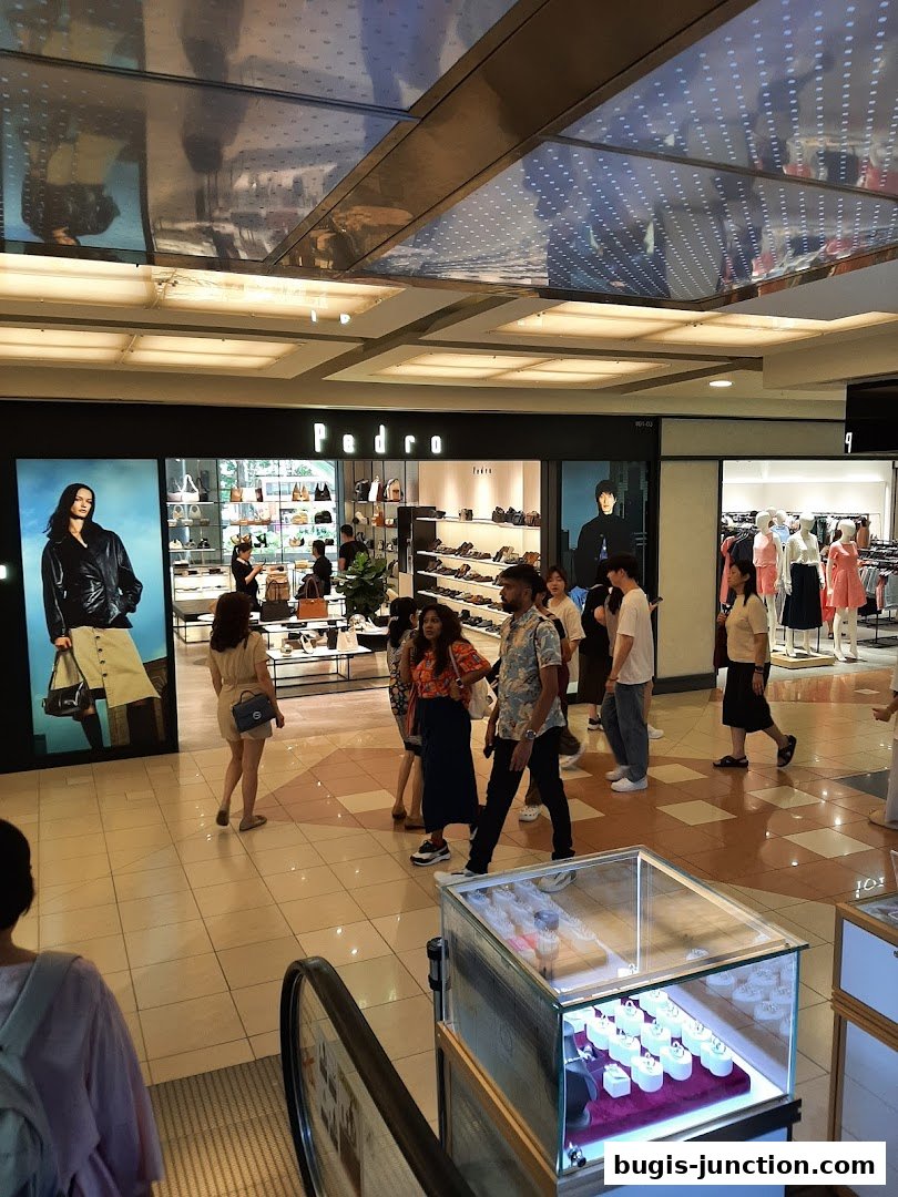 A Pedro store in a mall with displays of shoes, bags, and mannequins.