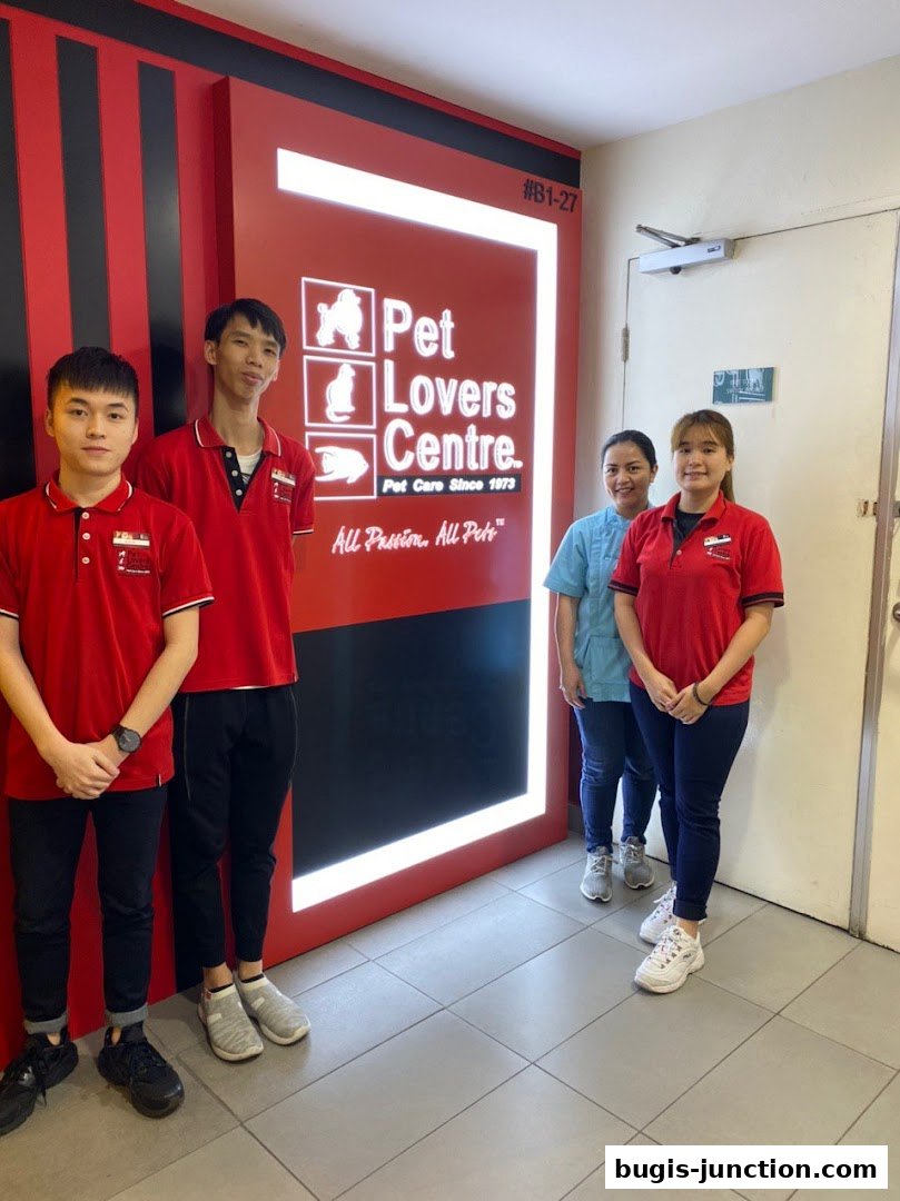 Four staff members stand in front of the Pet Lovers Centre sign.