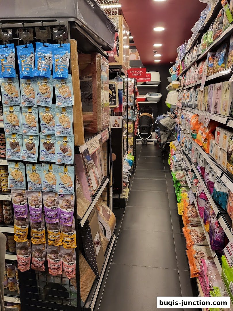Aisle in a pet store with shelves stocked with cat food, treats, and accessories.