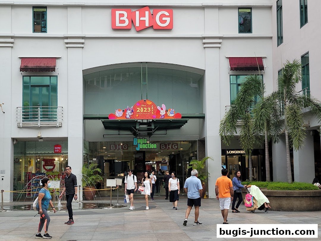 People walk in front of the BHG department store entrance at Bugis Junction.