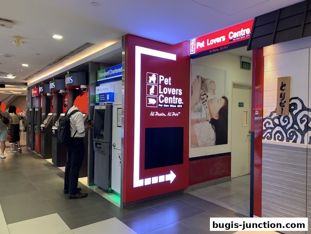 The entrance to Pet Lovers Centre, featuring its logo and a large advertisement with a woman and a cat.